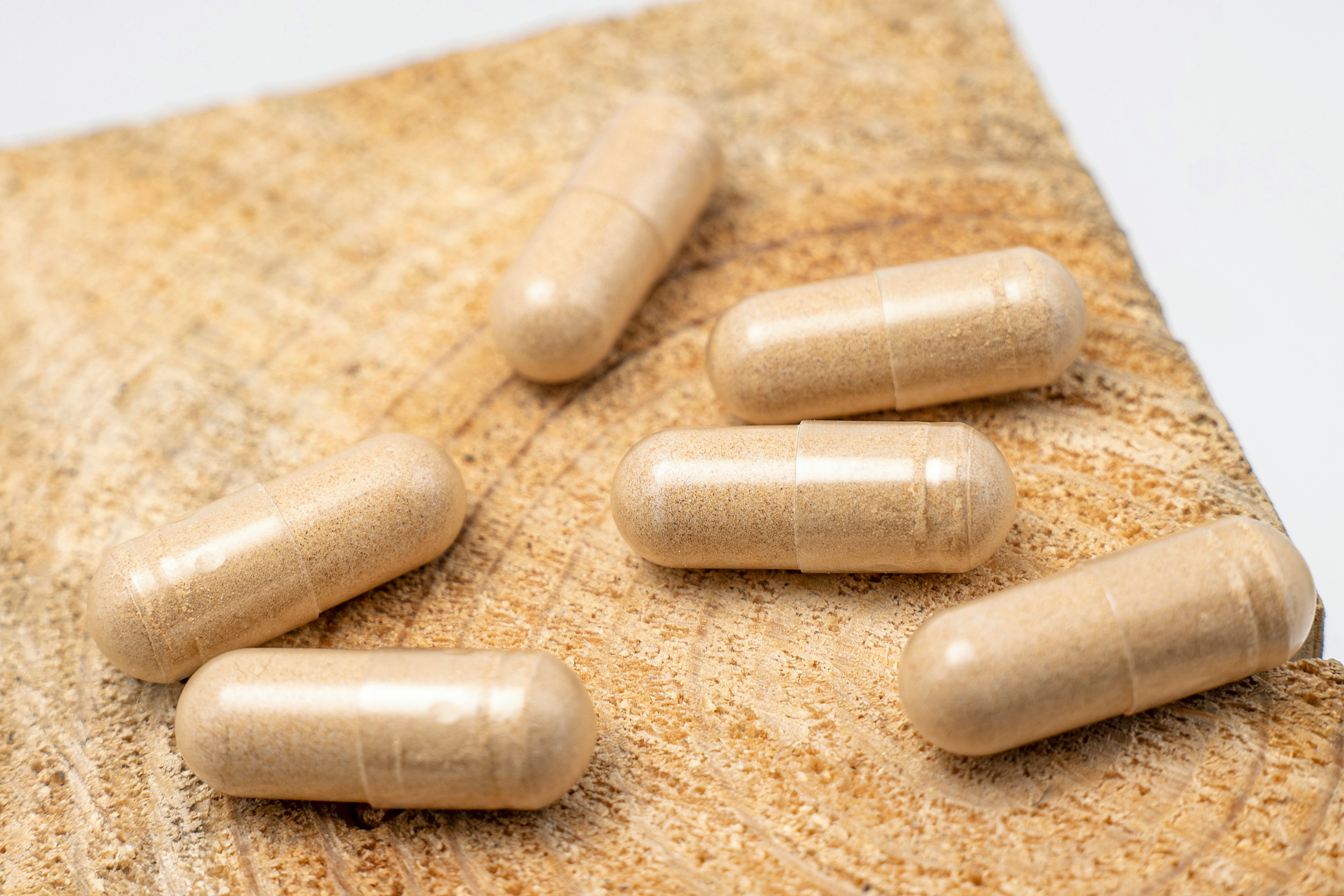 7-OH supplement capsules on wooden surface