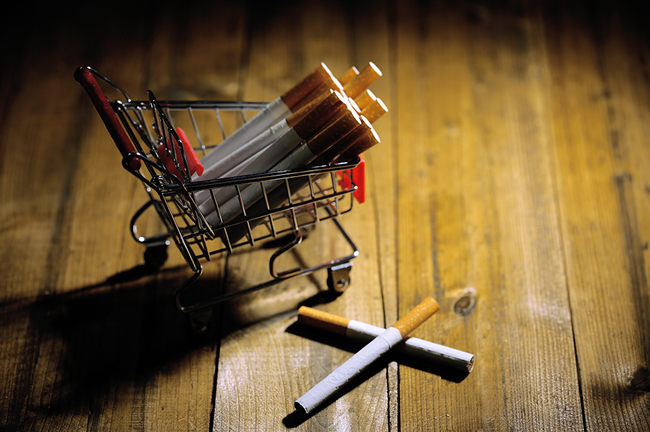 cigarettes-shopping-cart-wooden-table-dark-background