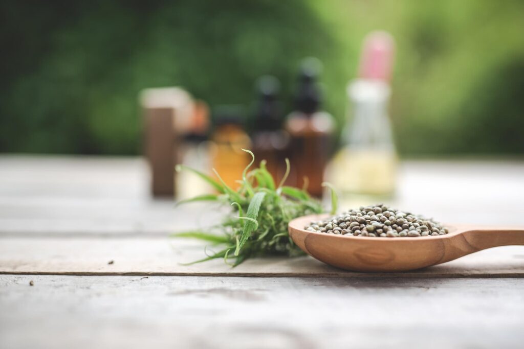 cannabis-cannabis-seeds-cannabis-oil-placed-wooden-floor-with-green-tree-background